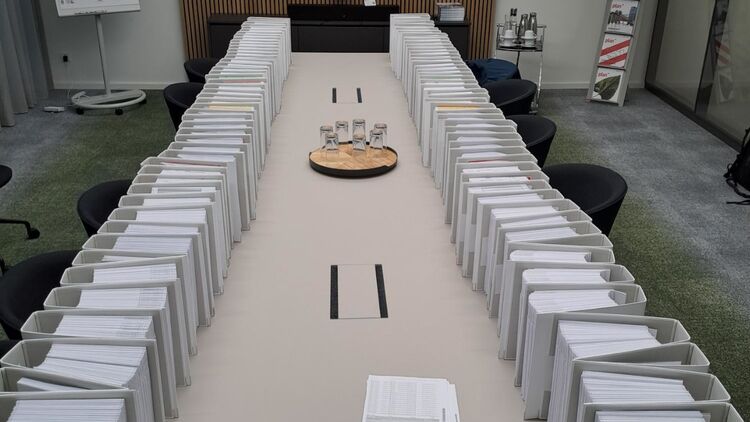 Auf einem Konferenztisch stehen in zwei Reihen die vielen Ordner mit Planunterlagen für den Abschnitt zwischen Zeppelinheim und Darmstadt Nord.